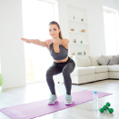 woman doing squat in living room