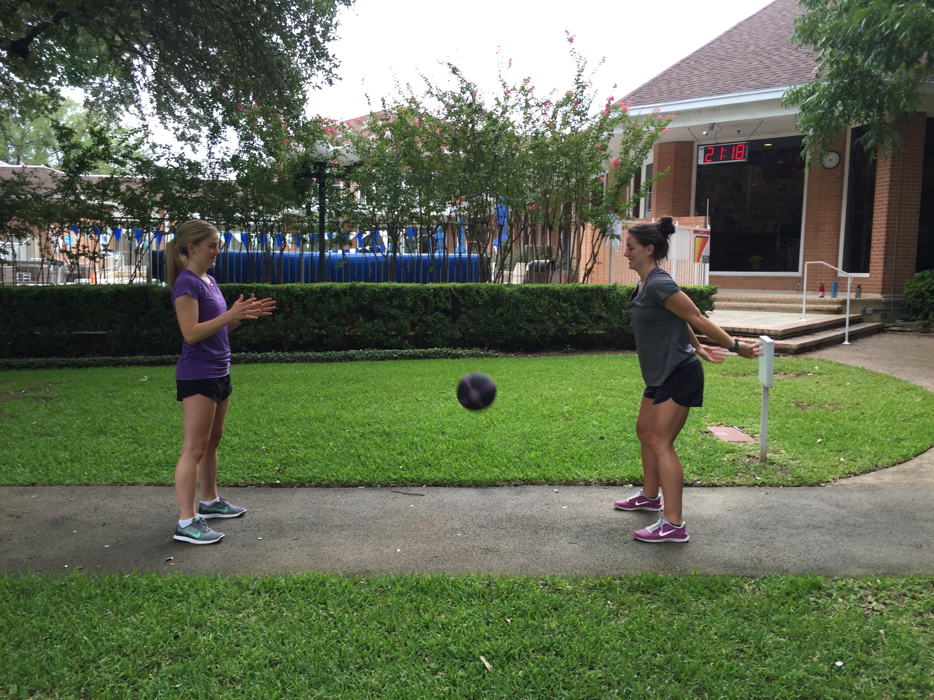 Two women doing the medicine ball slam exercise