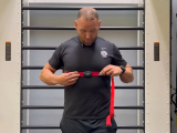 Trainer demonstrating how to put on a heart rate monitor