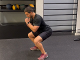 Professional fitness trainer demonstrating a body weight squat.