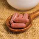 Red yeast rice supplements on spoon.