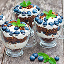 Three blueberry cheesecake parfaits topped with mint