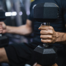 man with dumbbells on knee