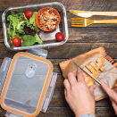 Packing meal in plastic container - salad with person cutting grilled chicken